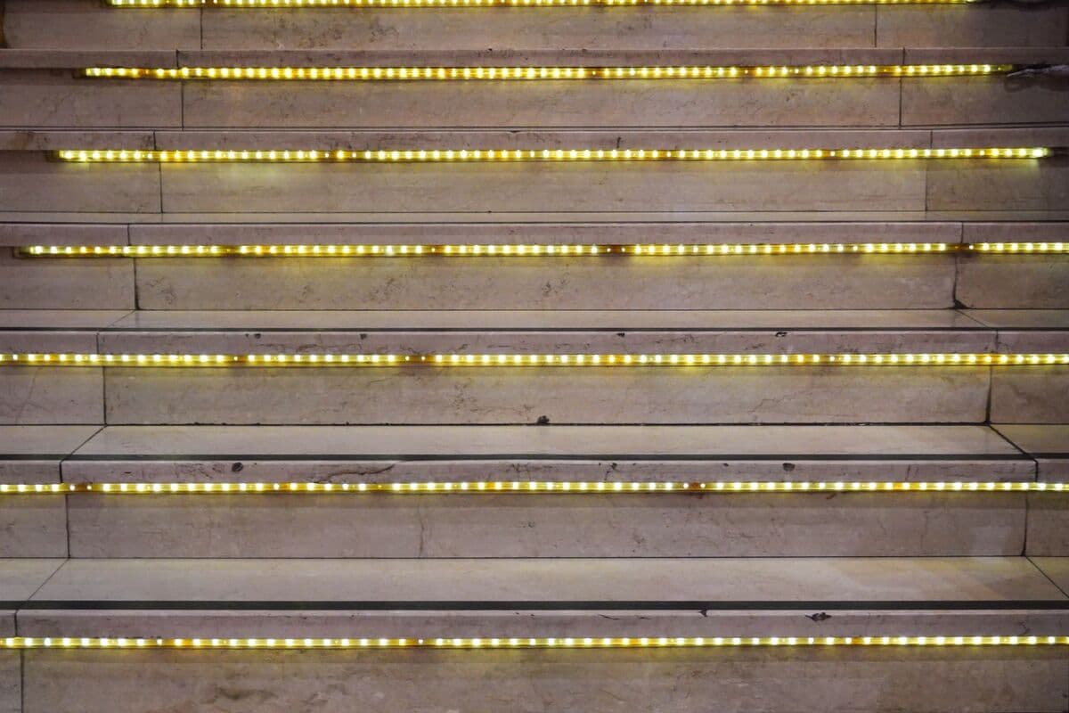 close-up of a staircase with a glowing LED strip under every step